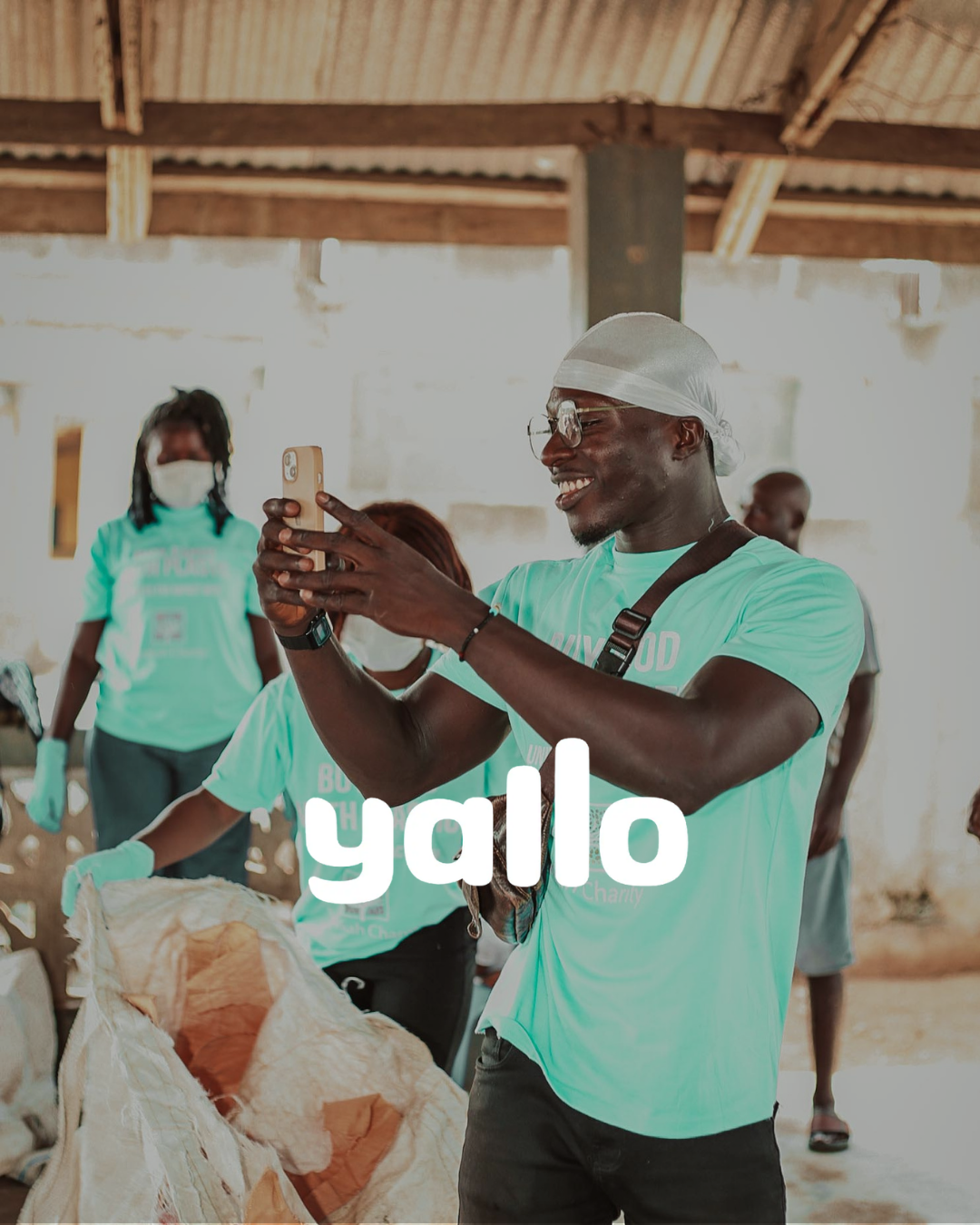 buy food with plastic employee in ghana holding his phone with a big smile